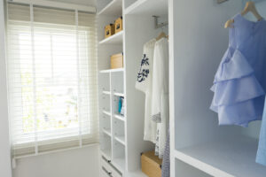 White wardrobe with shirts and pants hanging