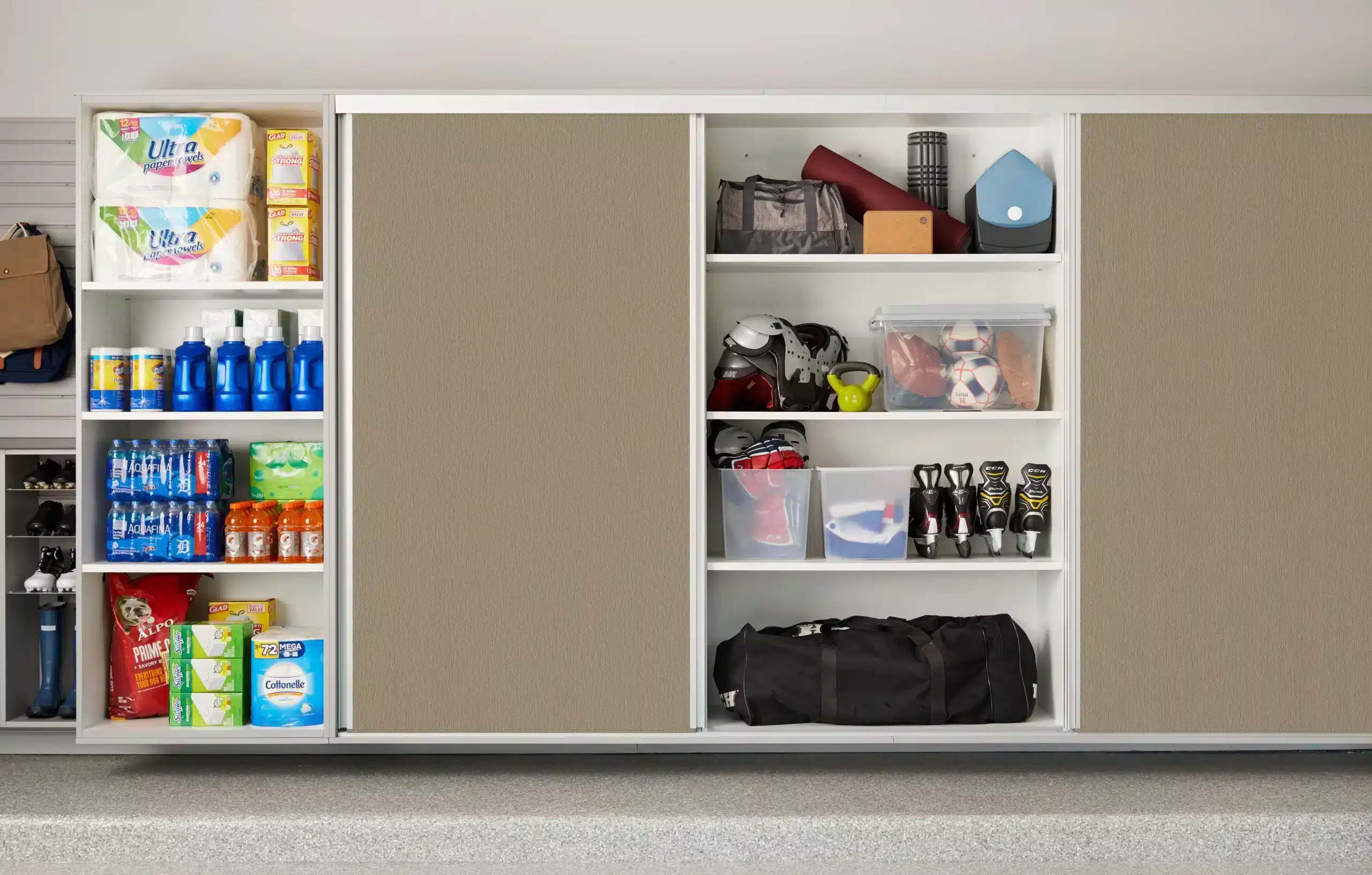 A neatly organized storage cabinet with shelves, featuring closet storage for cleaning supplies, paper products, sports equipment, bags, and various household items. Closet Concepts of Grand Rapids