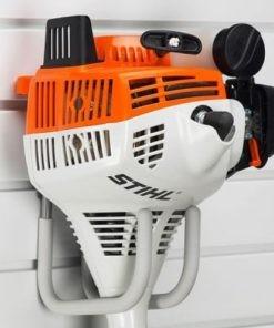 A Stihl gas-powered engine with orange and white casing, mounted on a wall rack. Closet Concepts of Grand Rapids